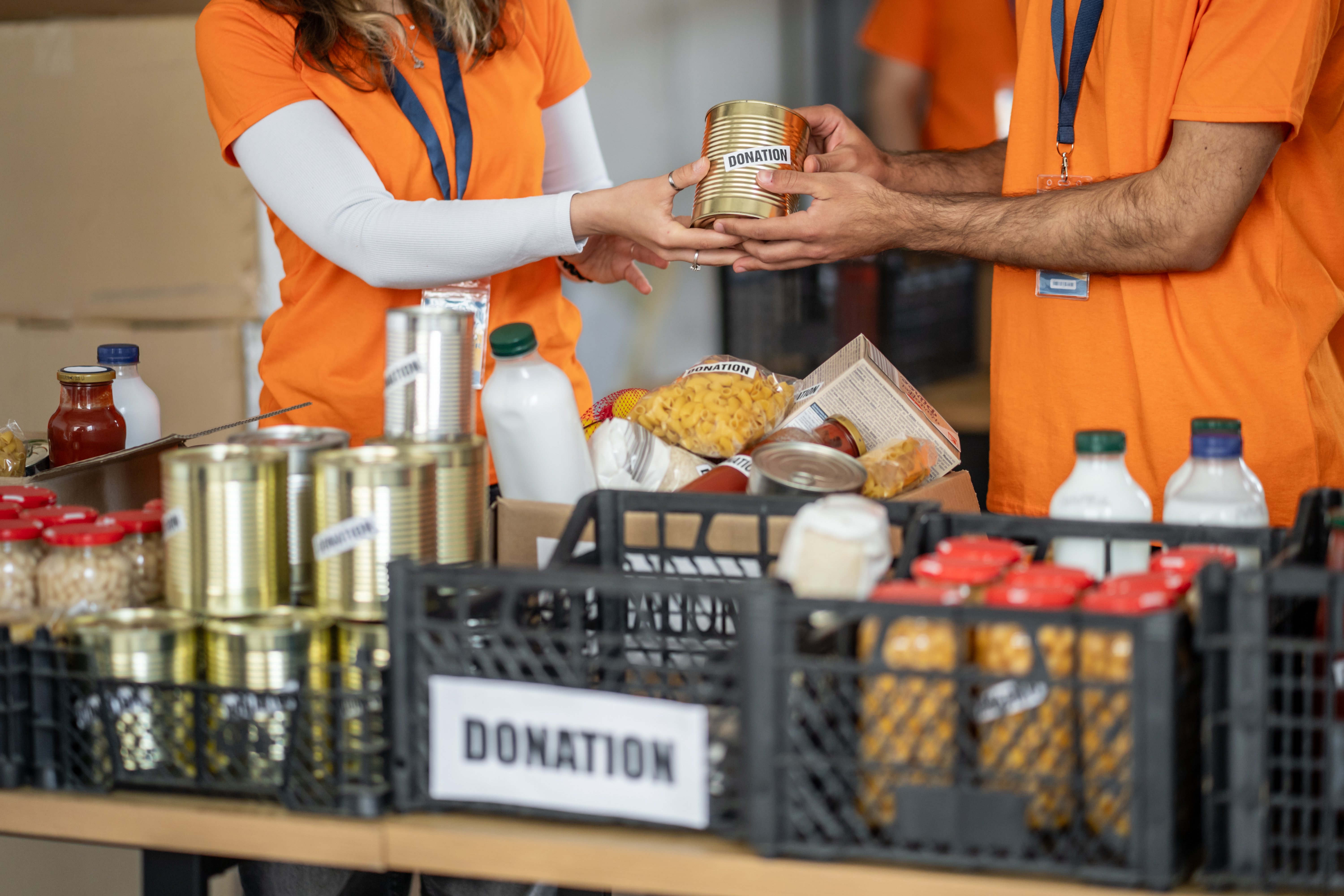 Volunteers collecting food donations from people for a community charity service
